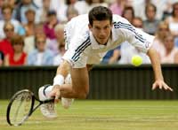 Henman stumbles as he returns the ball to Andre Sa.